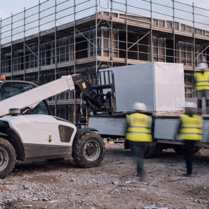 Lieferlogistik auf der Baustelle – Teleskoplader entlädt Baumaterial vor dem Gerüst